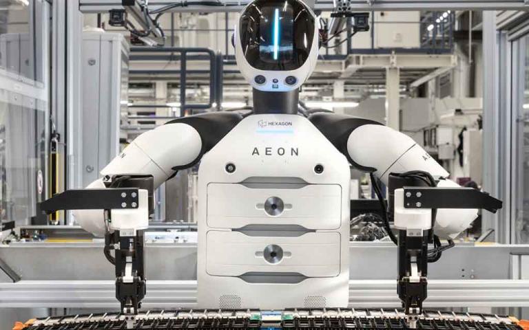 BMW AEON humanoid robot working alongside factory employees at the Leipzig plant during electric vehicle battery assembly